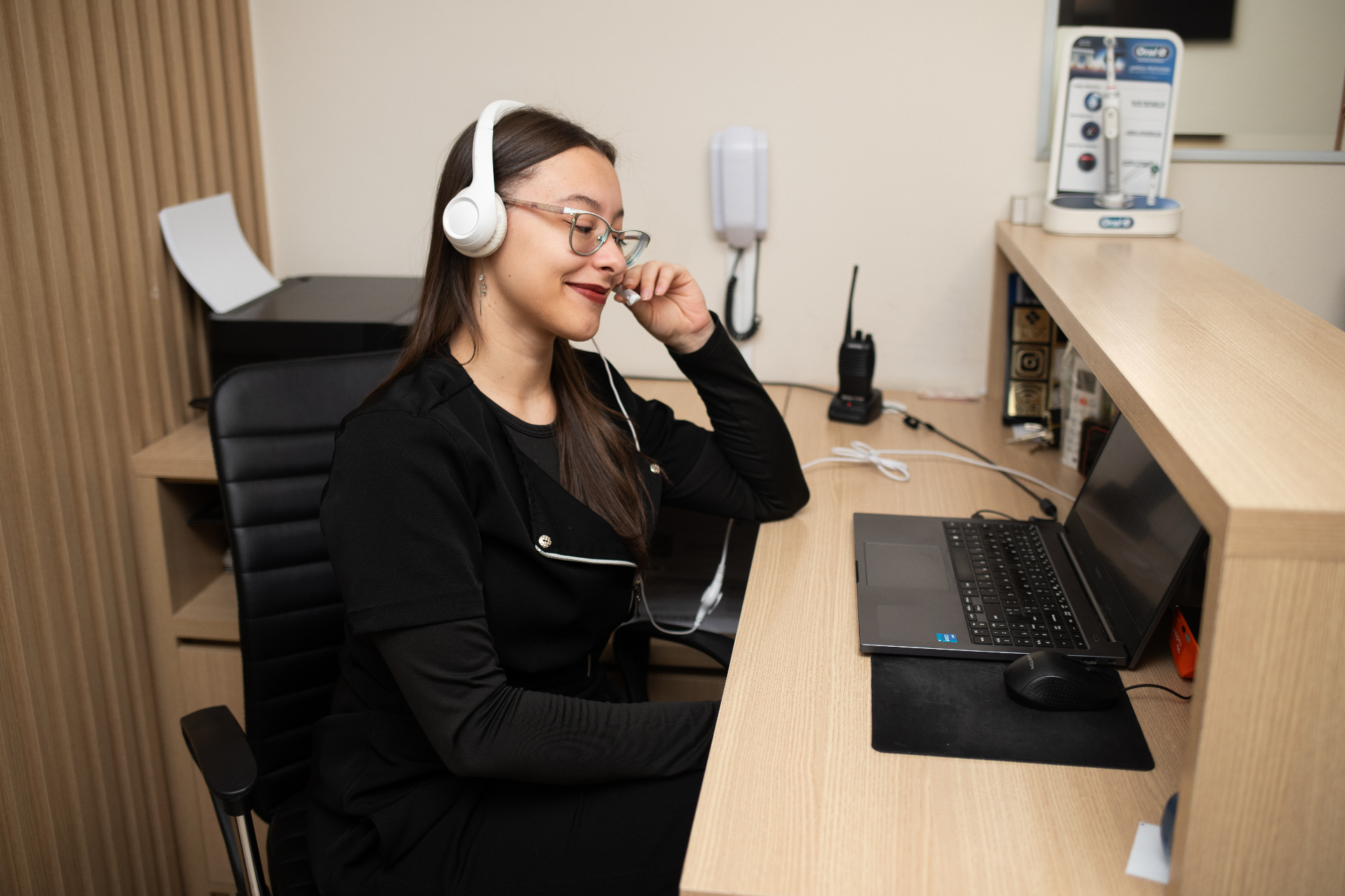 Recepcionista atendendo com headset na recepção